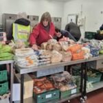 Volunteer arranging food on a Foodshare table